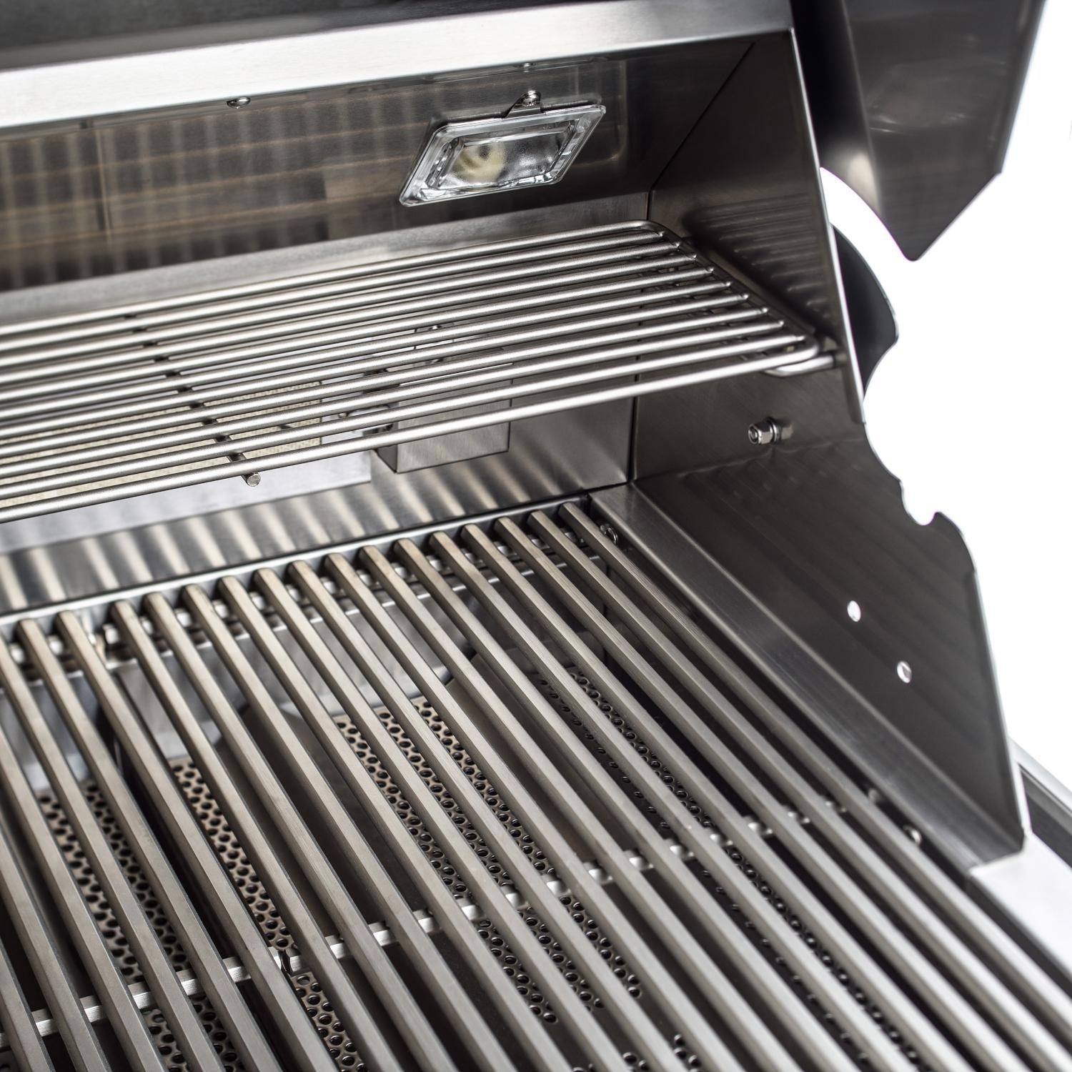 Stainless steel grill interior with cooking grates and a side heat shield