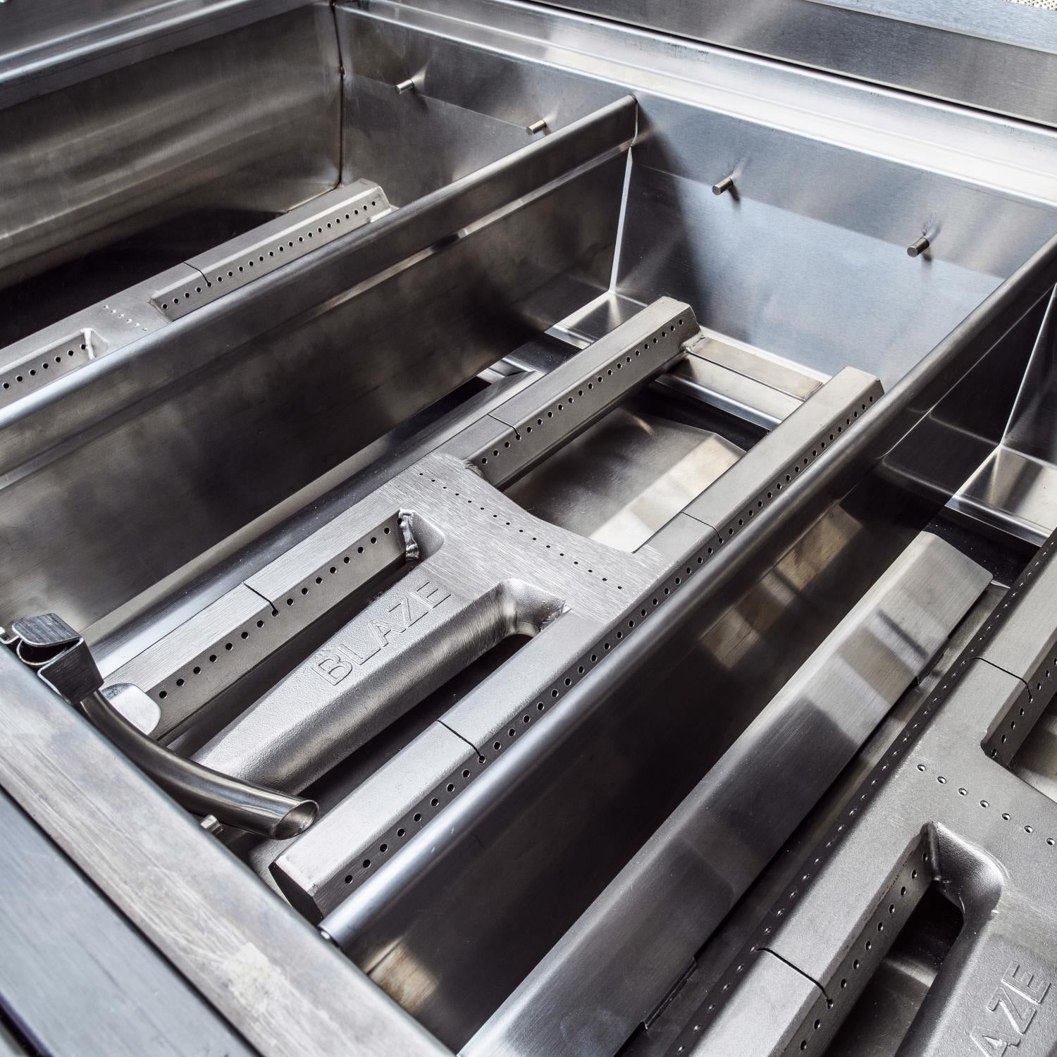 Built-in stainless gas grill interior with four burner bars and rear infrared grate