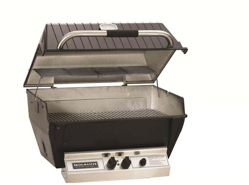 Black built-in natural gas grill with open lid, burner knobs, and stainless interior