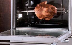 Double wall oven interior with roasting tray on the rack and open door