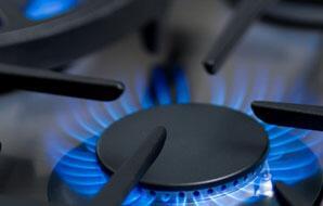 Gas cooktop burner flame with black burner cap and grate