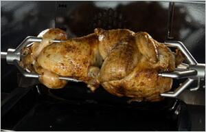 Roasted chicken on dual fuel range oven rack with spit-style supports