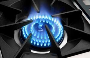Stainless steel gas burners with blue flames on the cooktop