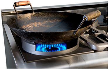 Stainless gas range cooktop with black griddle and blue burner flame
