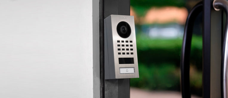 Stainless steel video intercom installed on the wall edge with camera and keypad