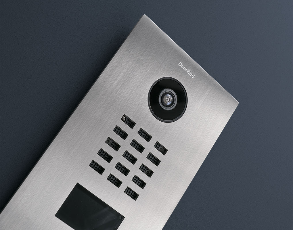 Stainless steel video door station angled view, circular camera lens and call keypad
