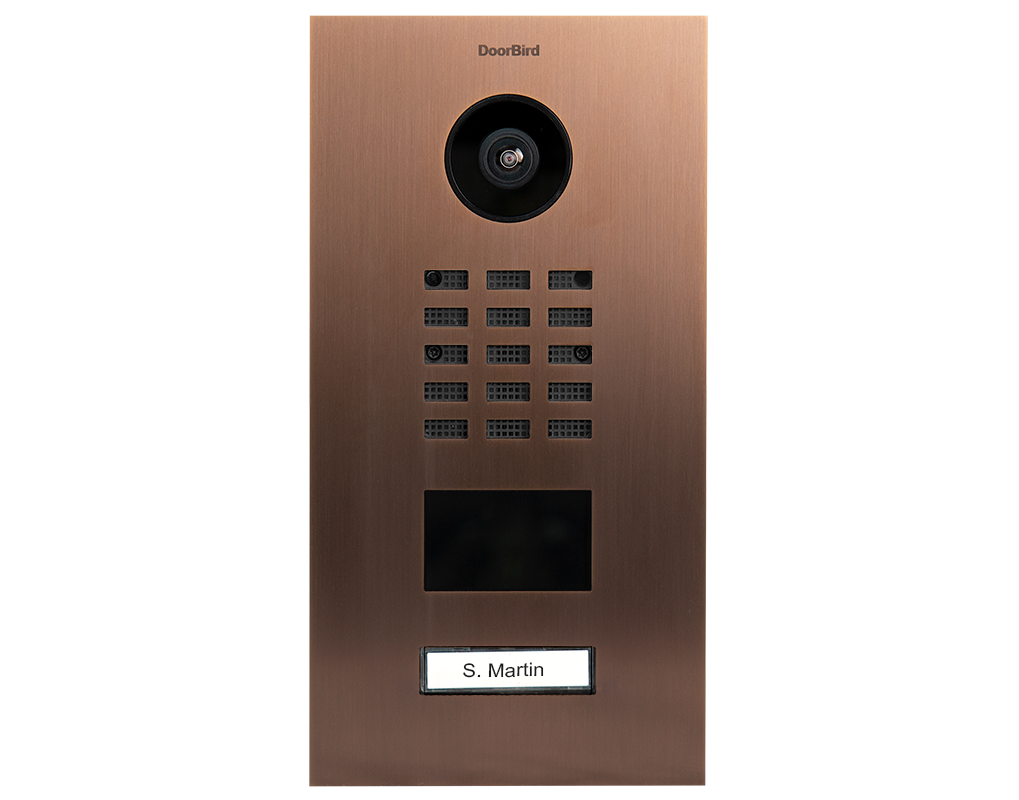Bronze DoorBird video door station front view with camera lens, keypad, and name label