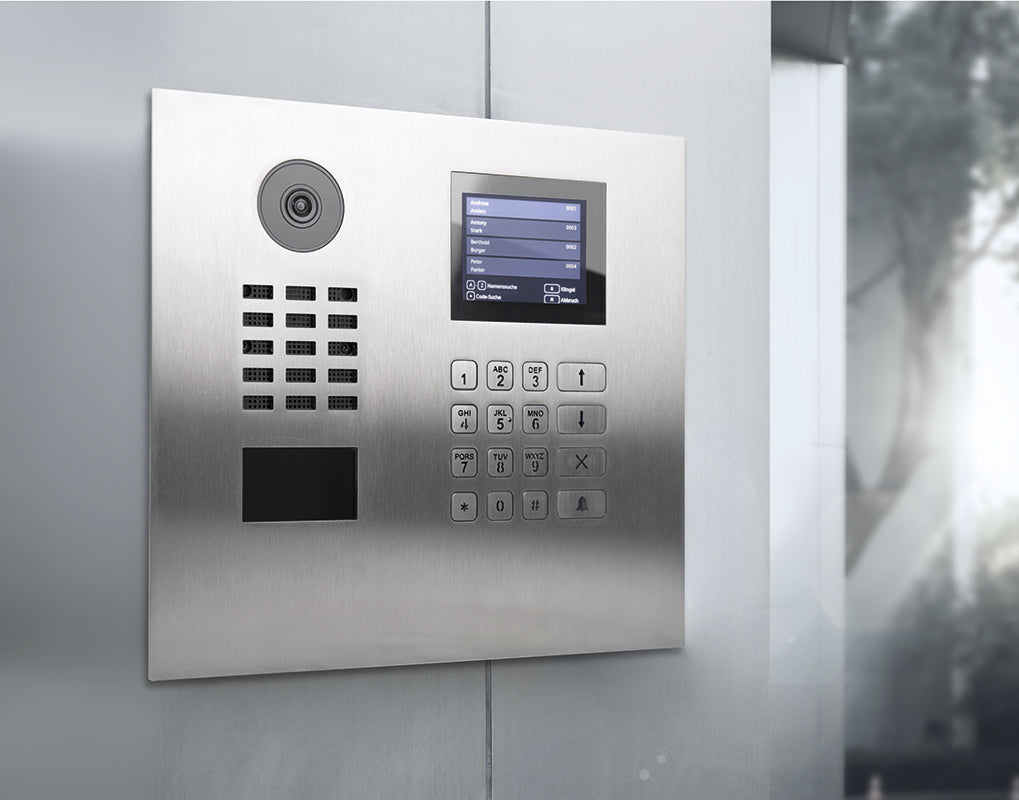 Stainless steel DoorBird video door station mounted on wall with touchscreen and keypad