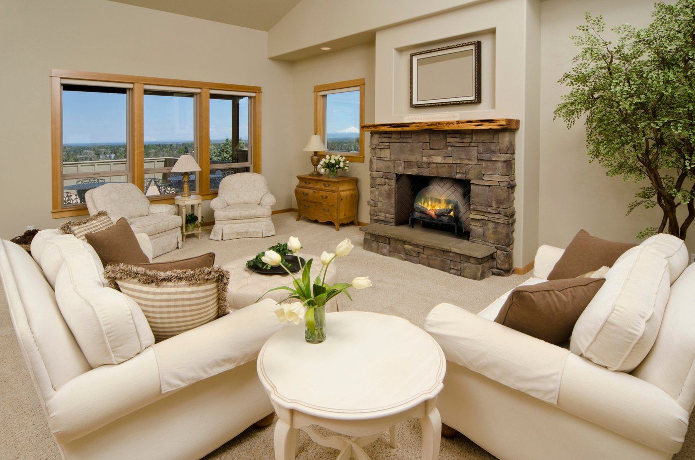 Electric log set burning in stone fireplace with mantel and home living room