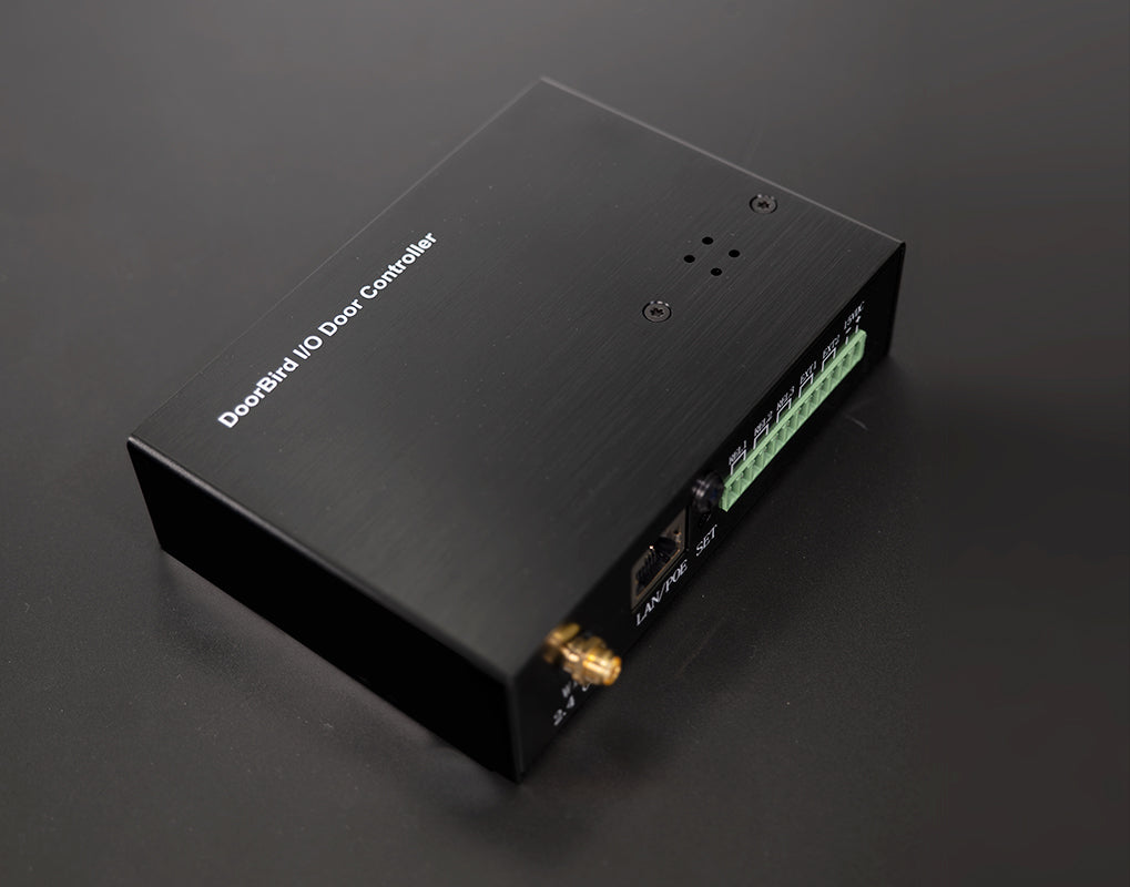 DoorBird IP I/O door controller angled view with green terminal strip and status LEDs