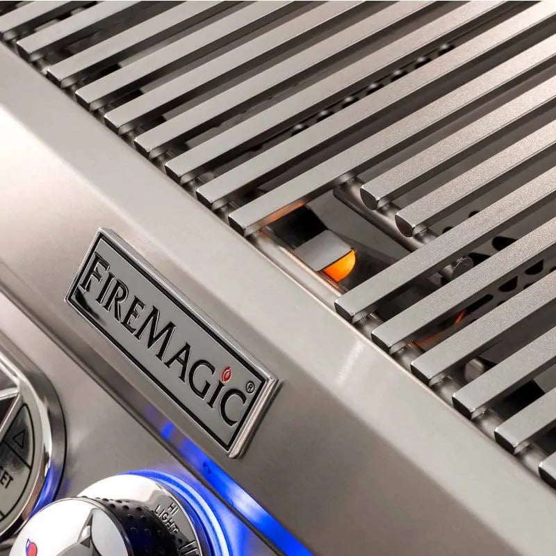 FireMagic logo plate on stainless grill near glowing burner grates