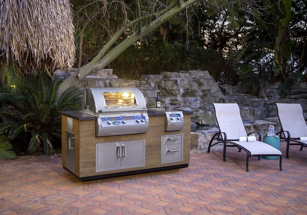 Stainless built-in gas grill with side controls and open cooking hood on outdoor kitchen