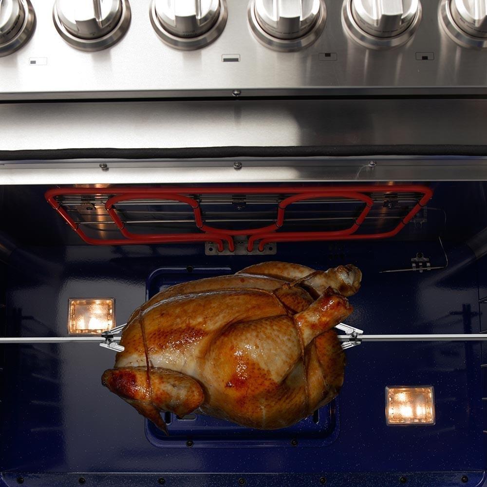 Dual-fuel range oven with a roasted chicken on the rack, viewed from inside.