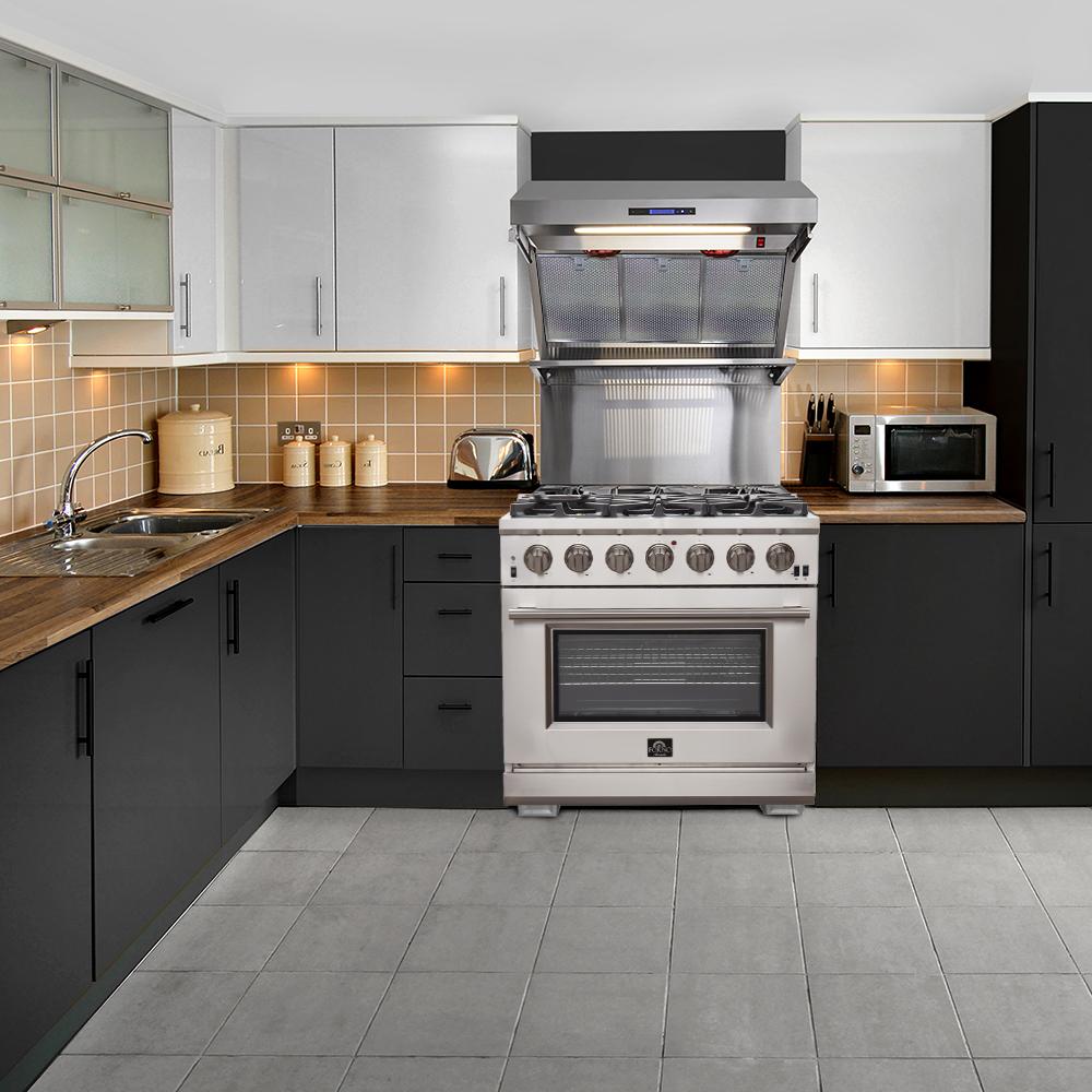 Stainless gas range in a kitchen setup with wall hood above and tiled backsplash