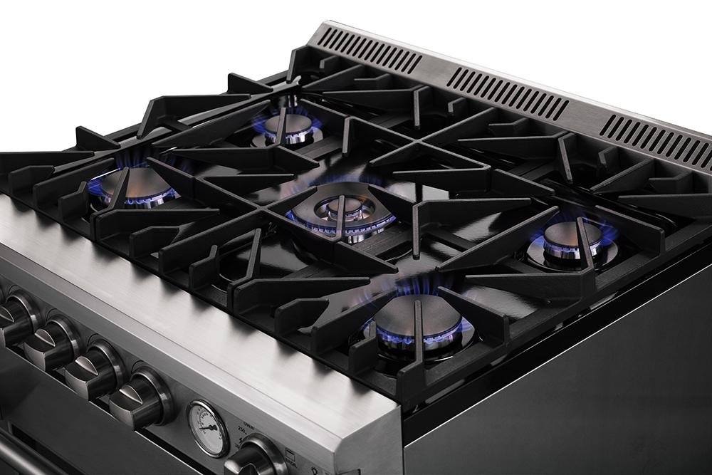 Stainless gas cooktop with five burners and lit blue flames