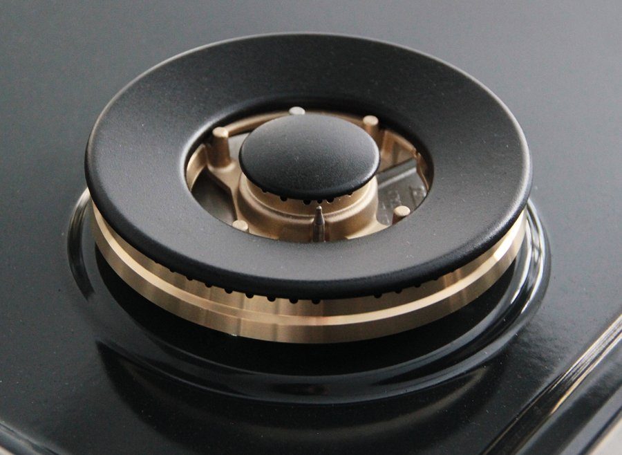 Single gas burner head with black cap and brass-colored ring