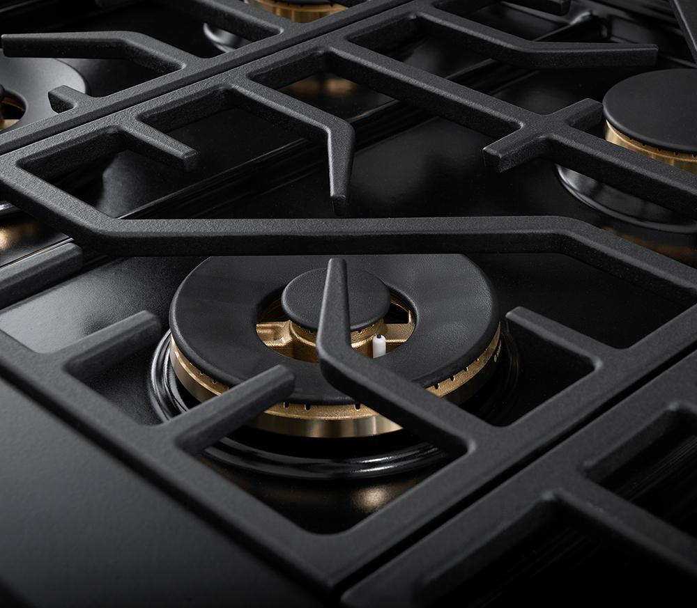 Black gas burner grate with round burner cap and ring of blue flame.