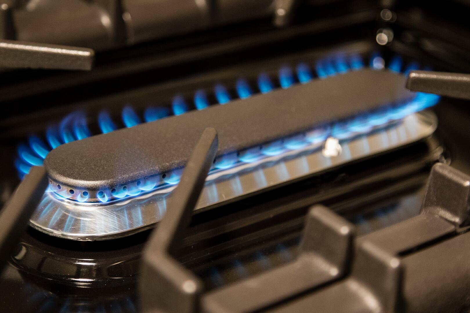 Black dual fuel range burner with blue flame and brass burner head