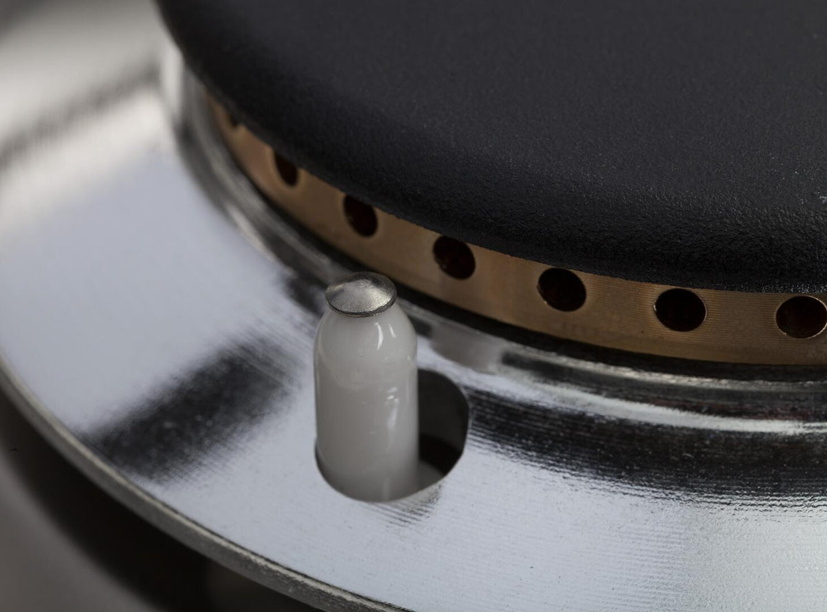 Dual-fuel range gas burner cap with bronze trim and black control ring