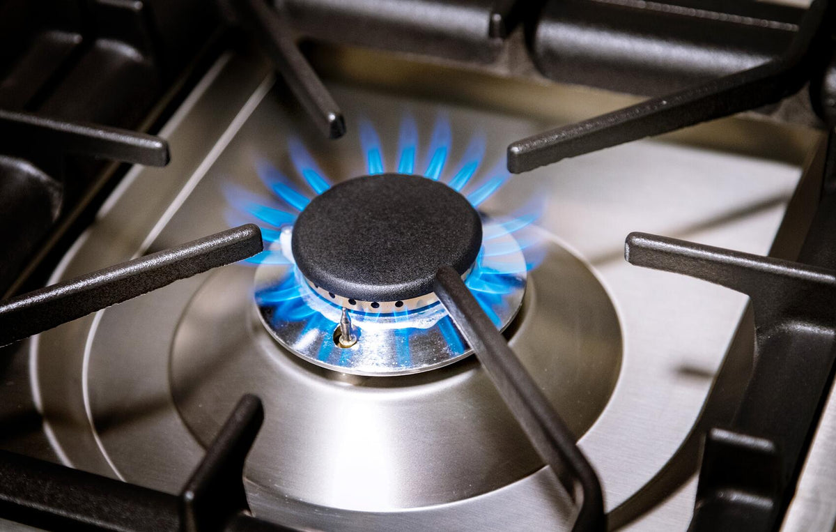 Single gas burner with blue flame and black burner cap on round base