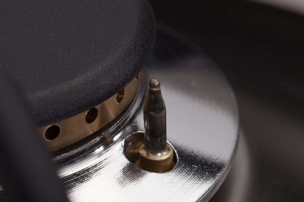 Dual-fuel range burner with bronze ring and black cap on silver grate