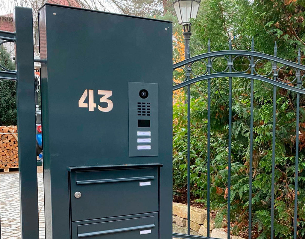 Outdoor metal video door station with camera, "43" label, and stacked call buttons