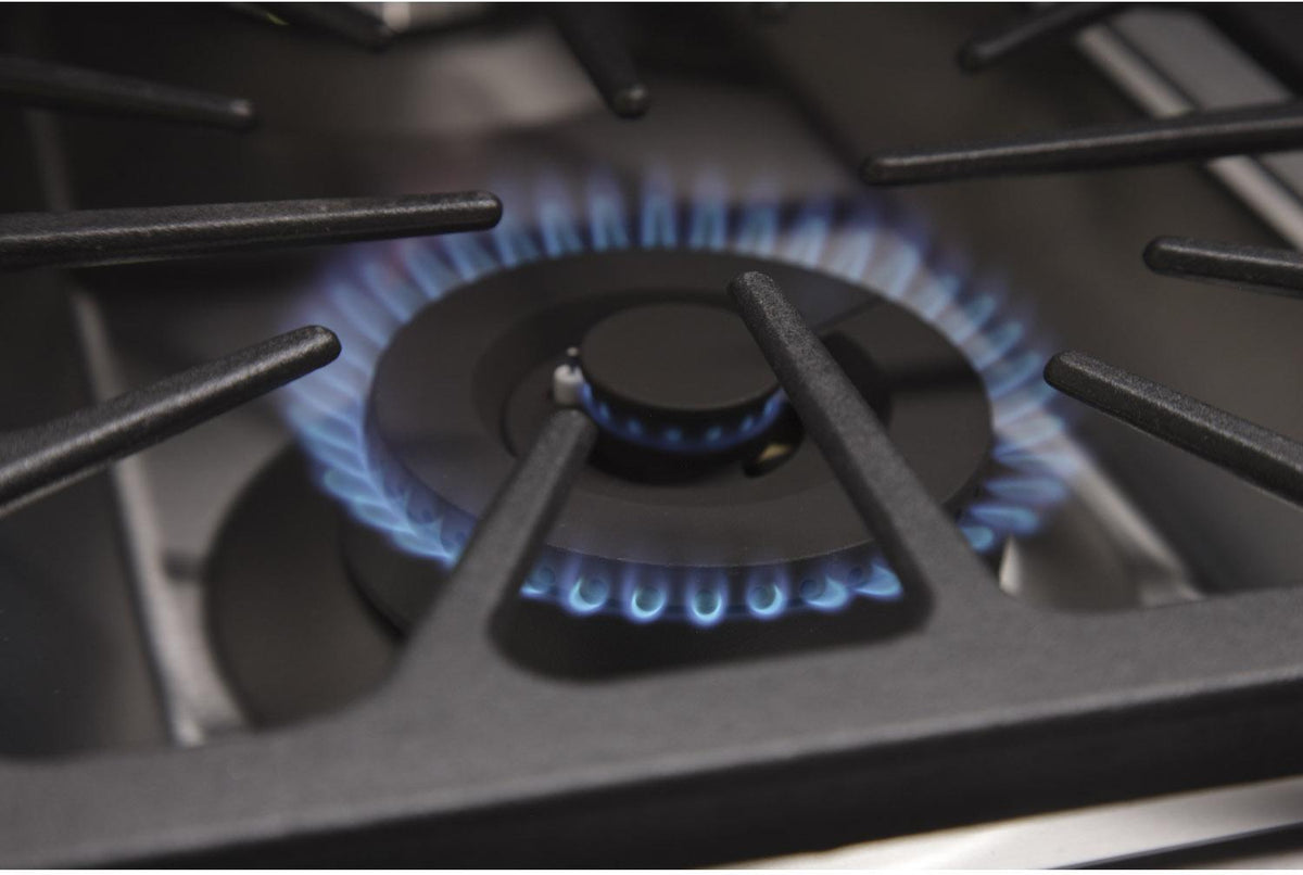 Stainless steel gas cooktop with blue flame on a burner grate