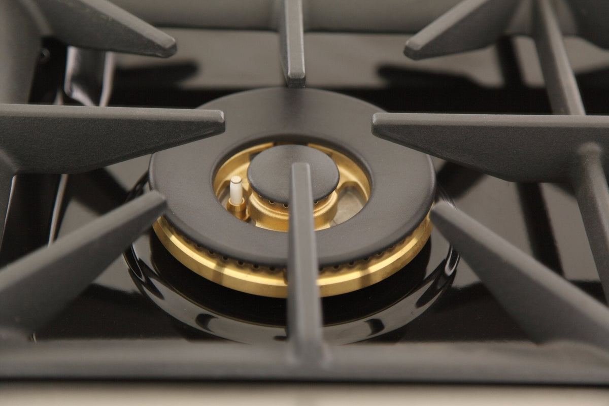 Gas range sealed burner with gold flame ring, centered in dark grates