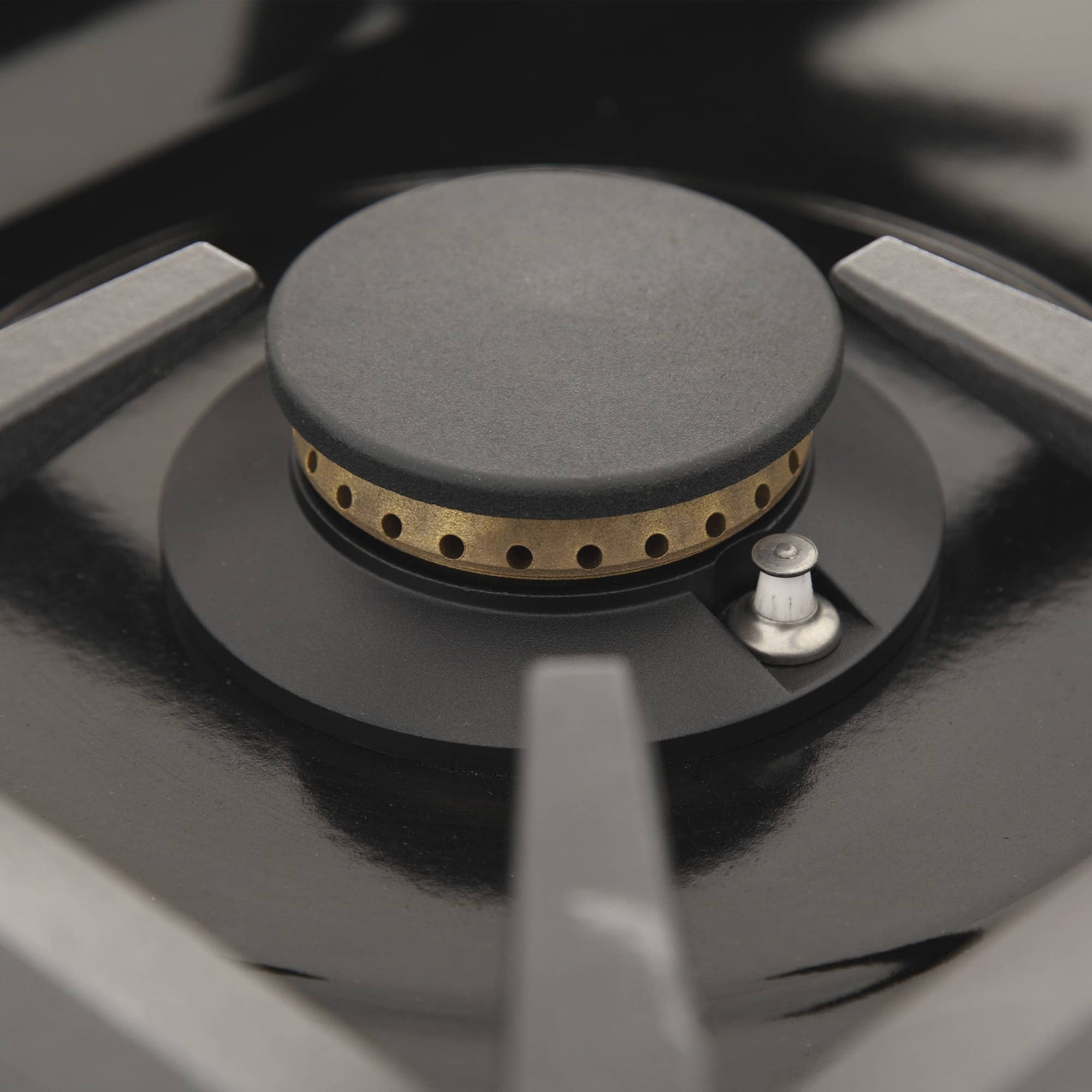 Gas burner with round cap and ignition control on the cooktop
