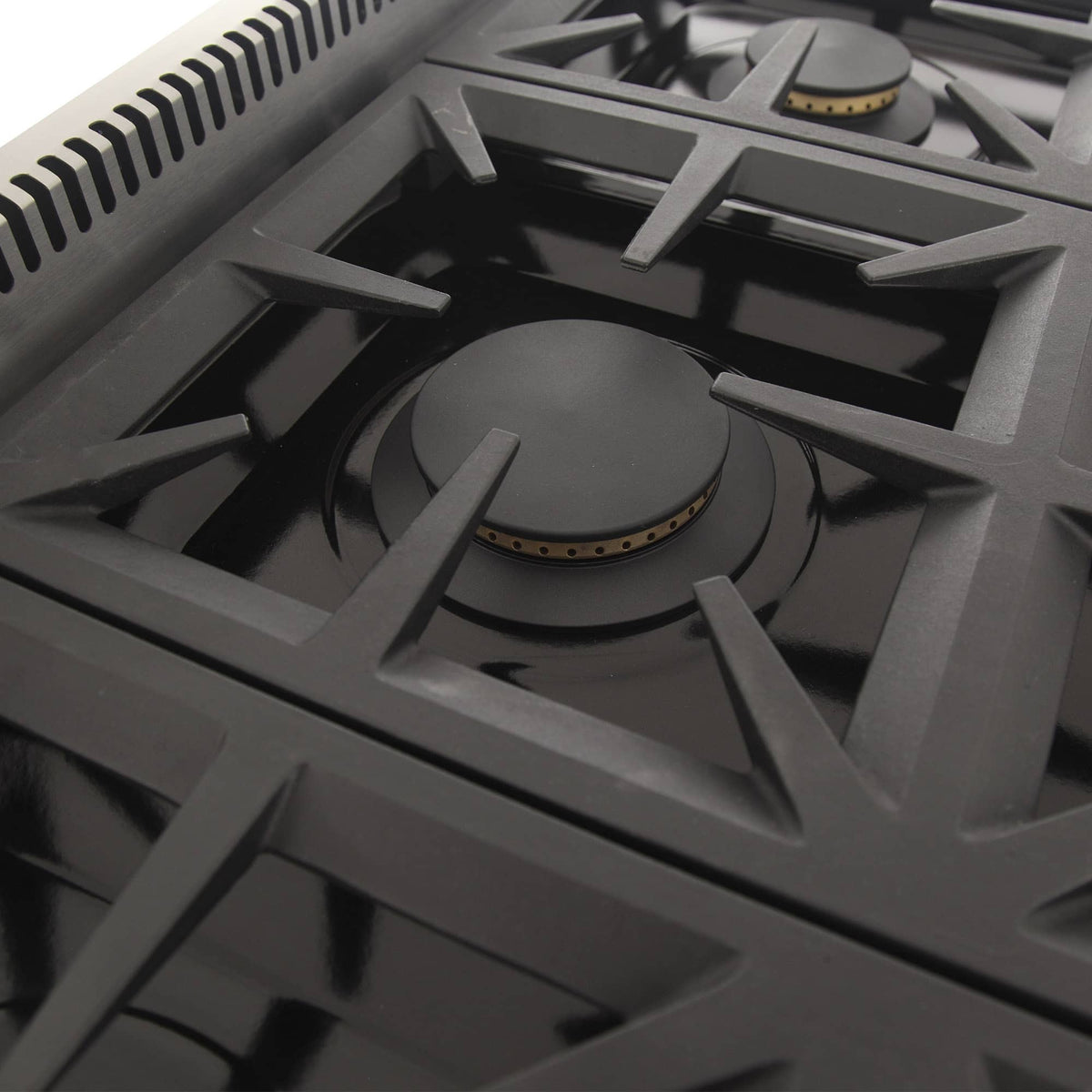 Close-up gas cooktop burner with cast-iron grate and burner ring