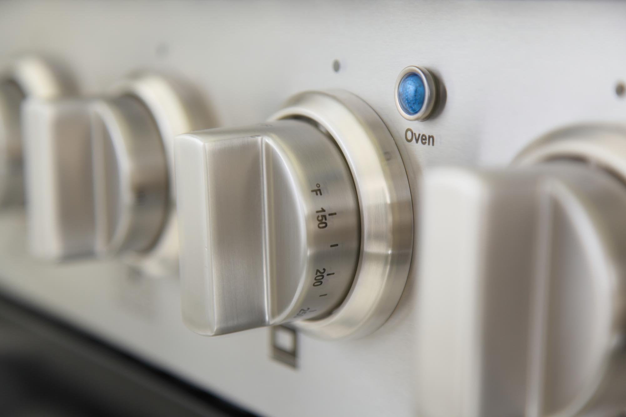 Oven temperature dial with blue indicator on gas range front