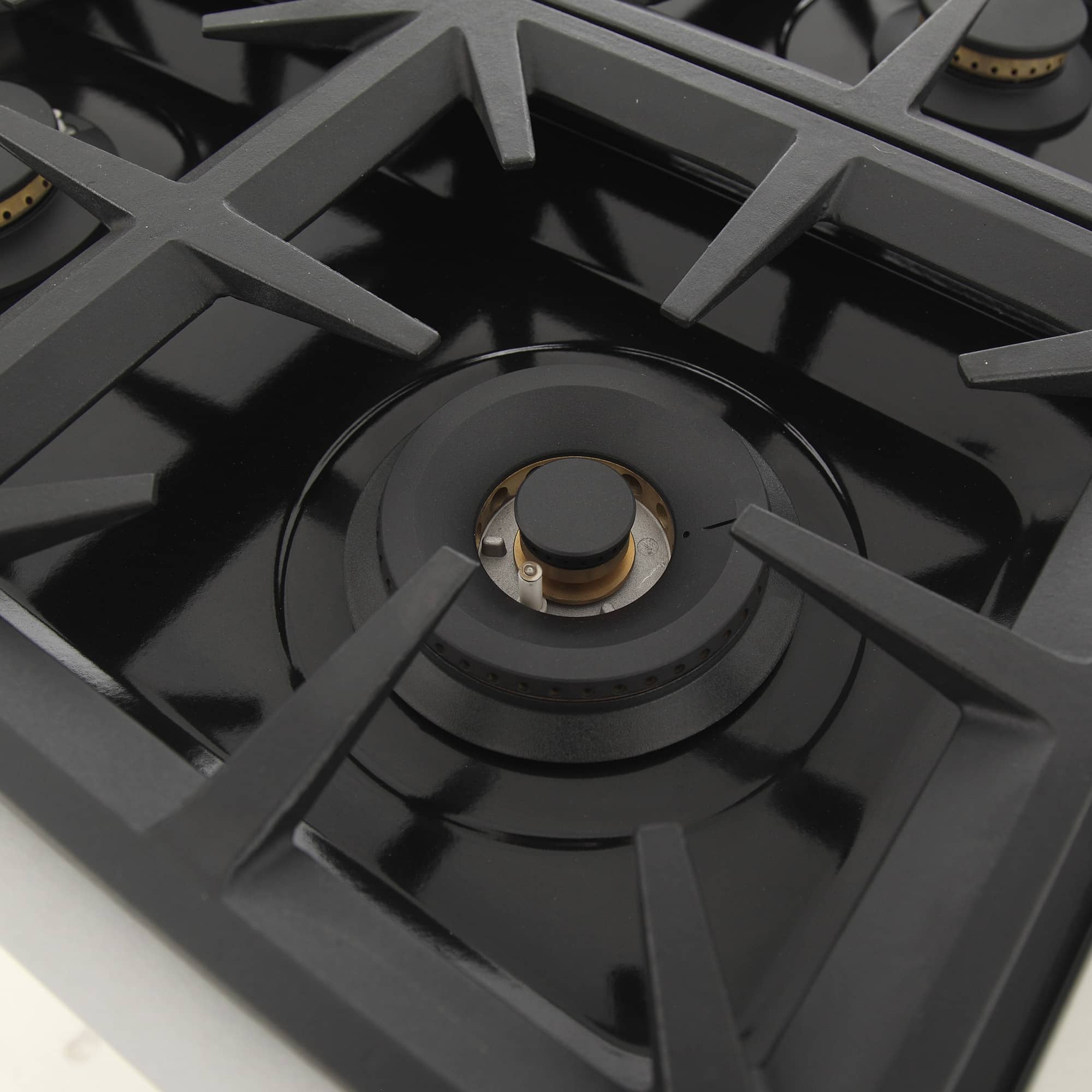 Gas range cooktop with cast-iron grates and central burner with control knob