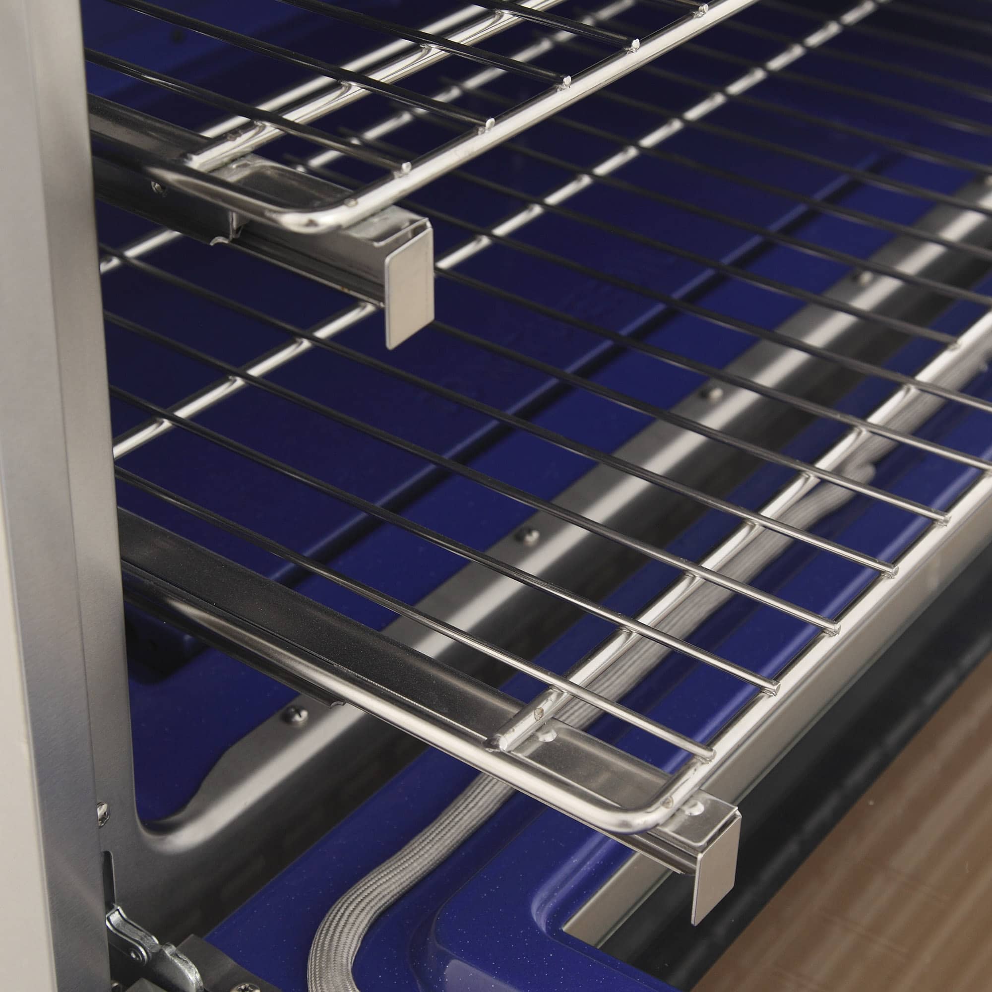 Blue oven interior with chrome wire rack and side rail supports