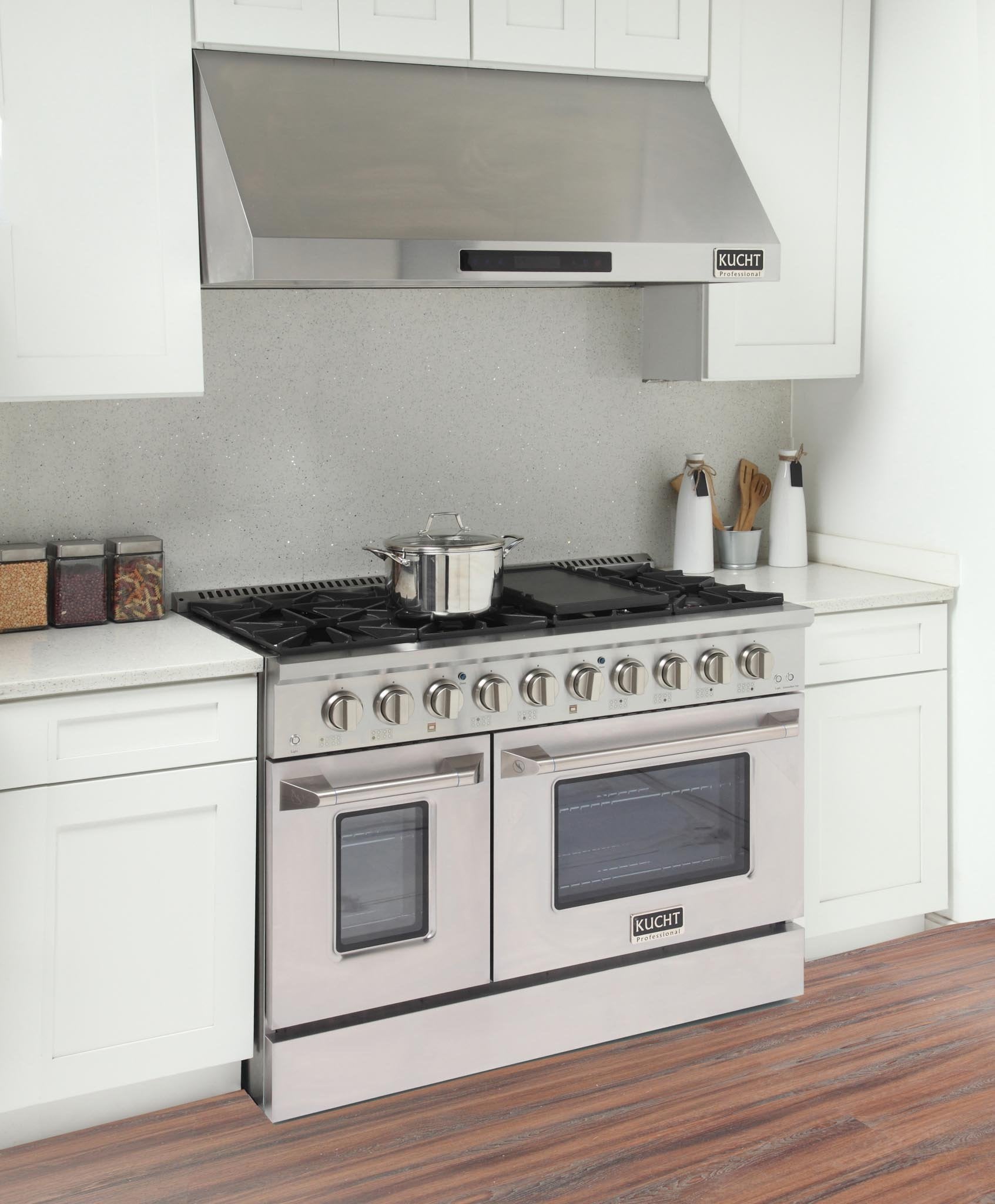Stainless steel gas range with two oven windows and six burner knobs in a kitchen
