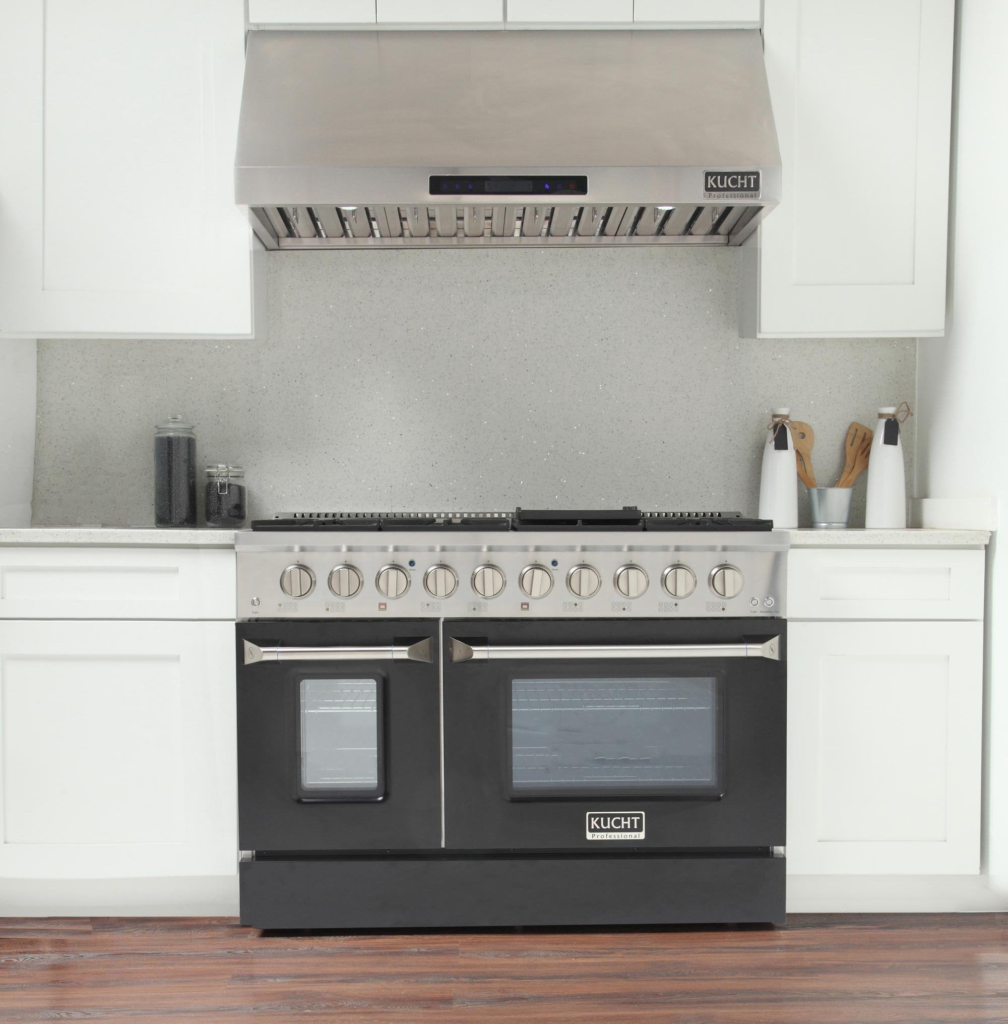 Black gas range with oven doors and burner knobs, stainless vent hood above cooktop.