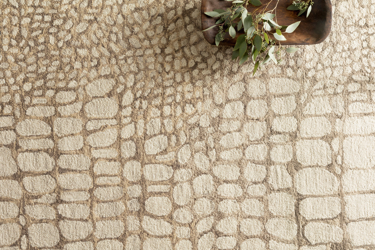 Neutral hooked rug with dense abstract stone pattern, close-up texture and loops