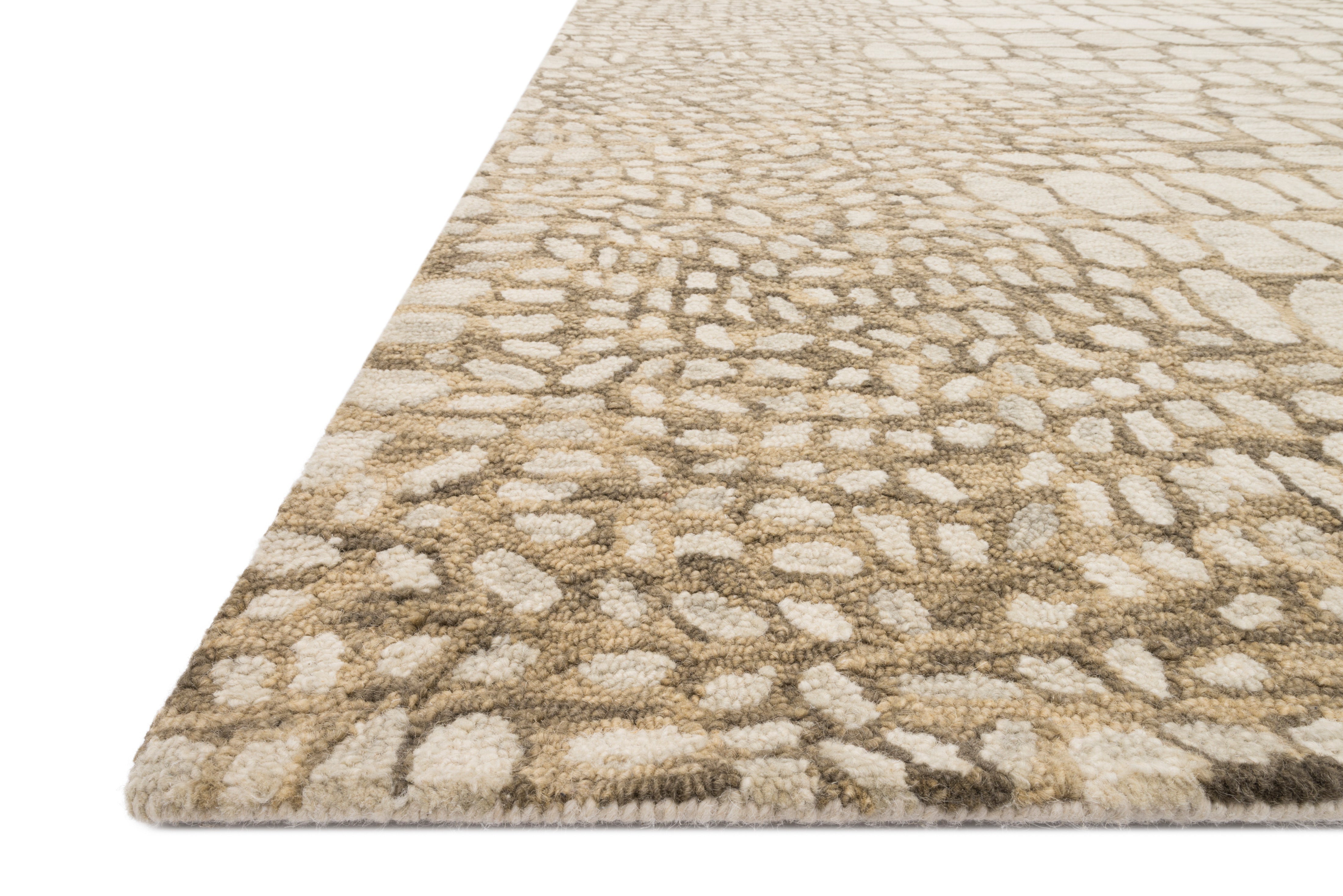 Neutral hooked rug with angled corner, stone-pattern texture and fringe edge