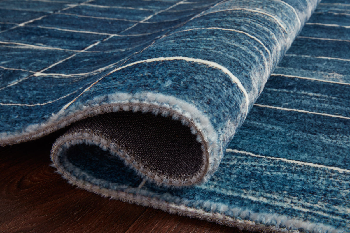 Rolled edge of denim and ivory grid hand-tufted rug with bound border
