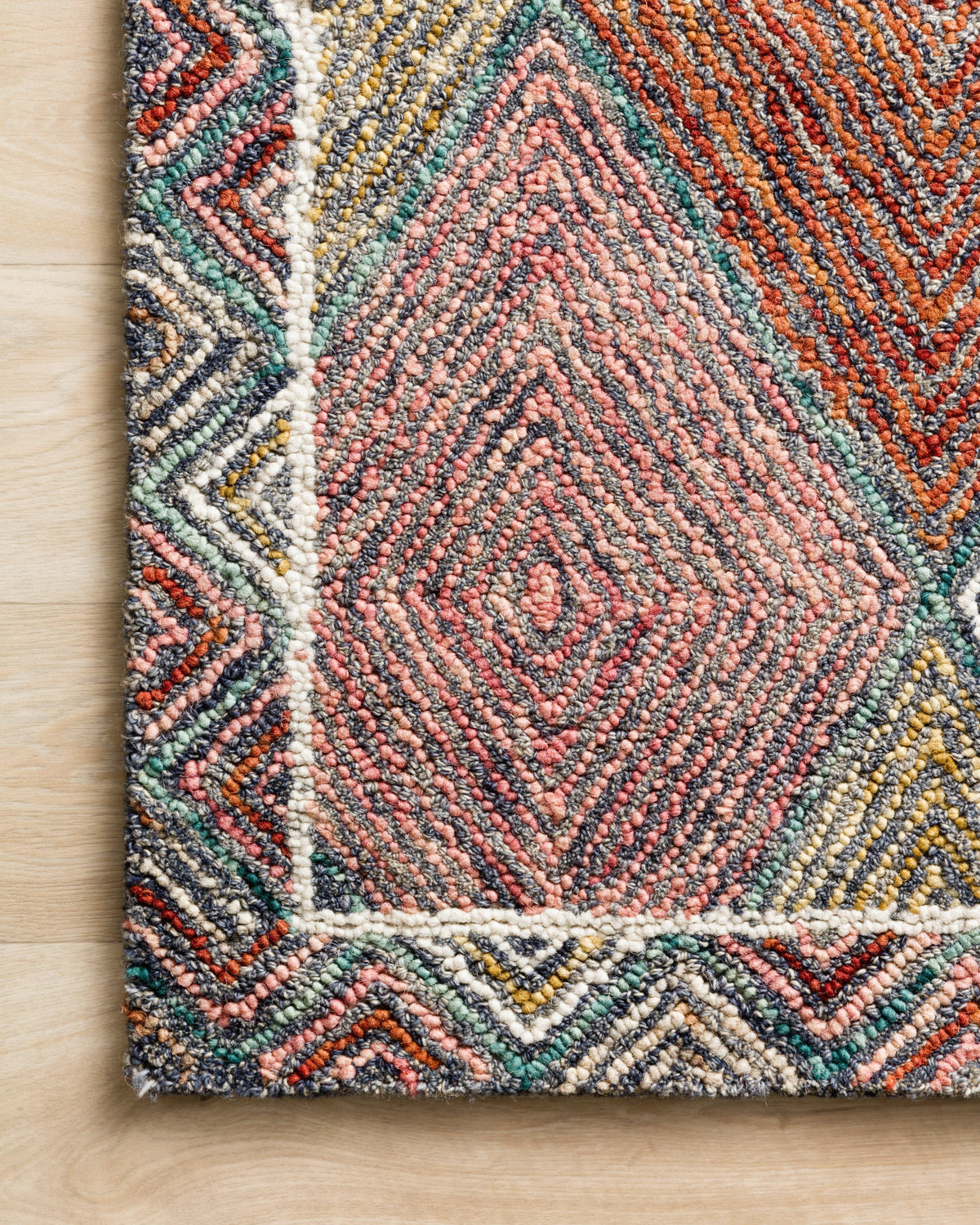 Multicolor hooked rug with diamond and chevron pattern, turquoise, coral, gray, and yellow