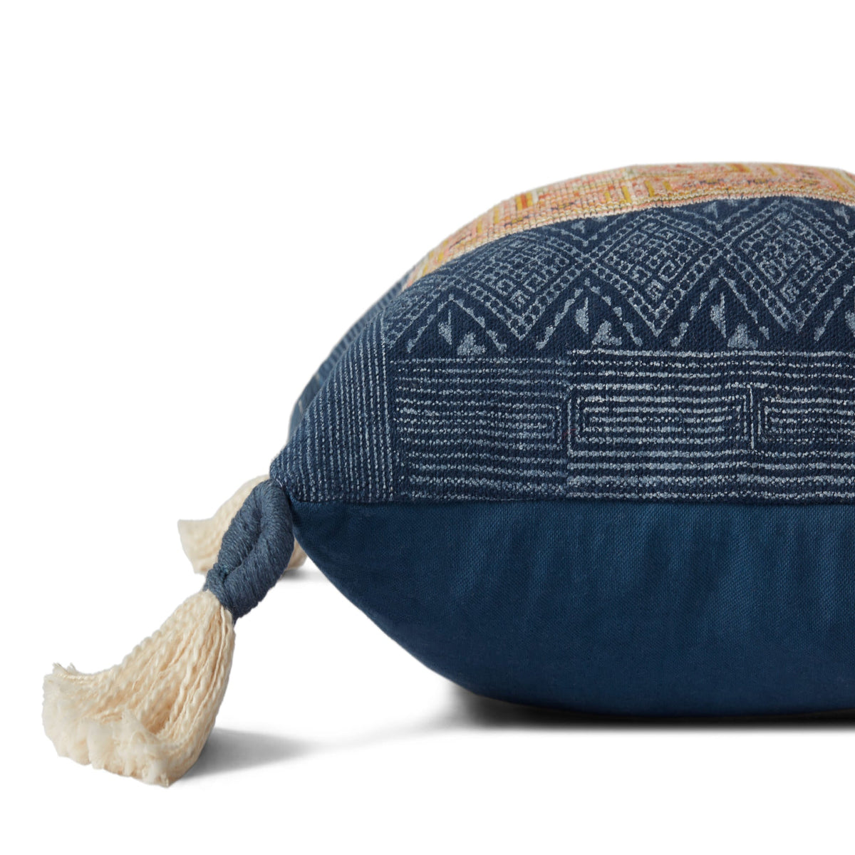 Navy geometric pillow with tan trim and cream tassel pom at corner