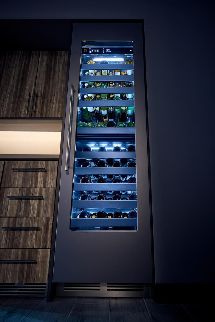 Built-in wine cooler with glass door, shelves lit, and bottles stored vertically