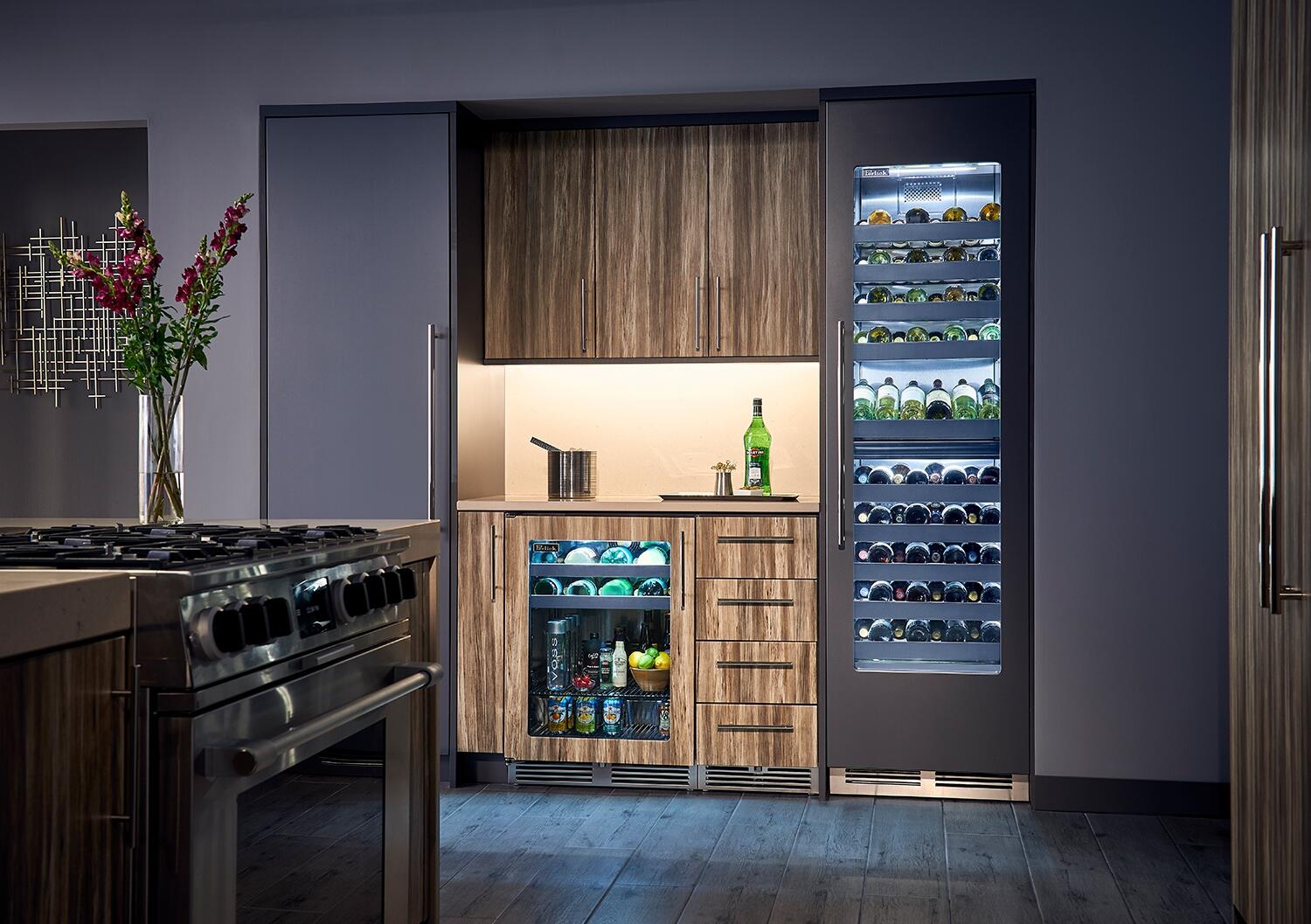 Built-in wine cooler unit with glass-door display and bottle-filled shelves in cabinetry