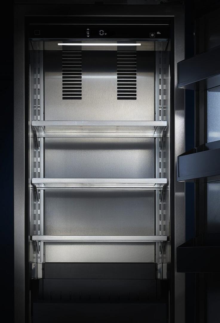 Upright freezer interior with interior light, pull-out shelves, and vented panels