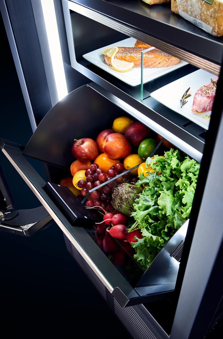 Built-in upright refrigerator door open, fresh food shelves with produce and deli items