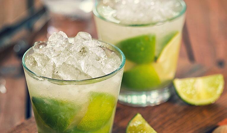 Ice cubes in a clear drink glass with lime wedges