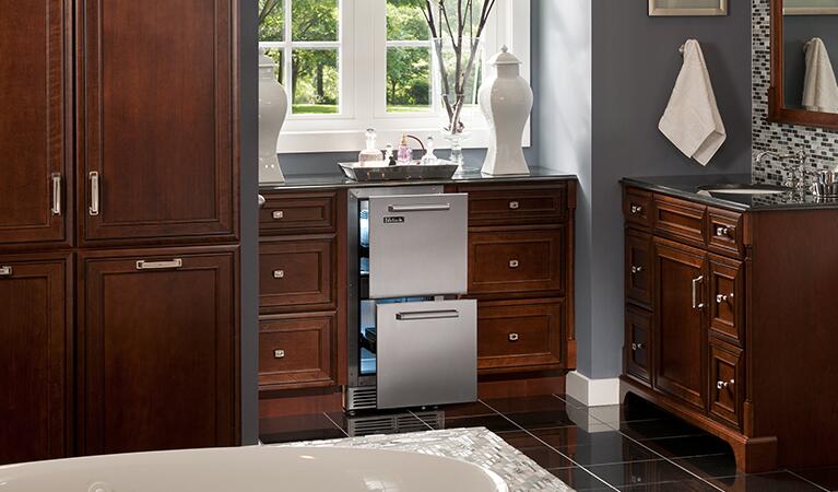 Built-in stainless steel drawer refrigerator installed between kitchen cabinets