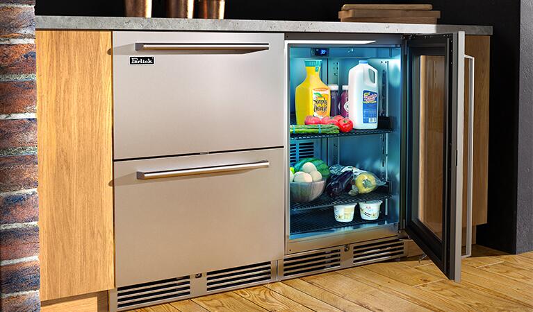 Perlick built-in stainless compact refrigerator with glass door open, stocked interior shelves