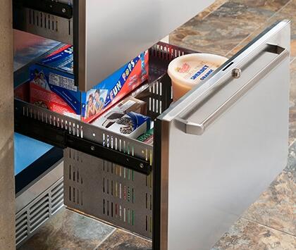 Opened freezer drawer with ice-cream tub and boxed items on shelves