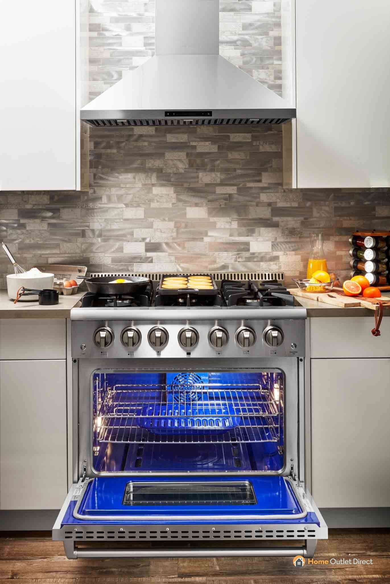 Stainless steel dual fuel range with open oven and visible cooktop burners