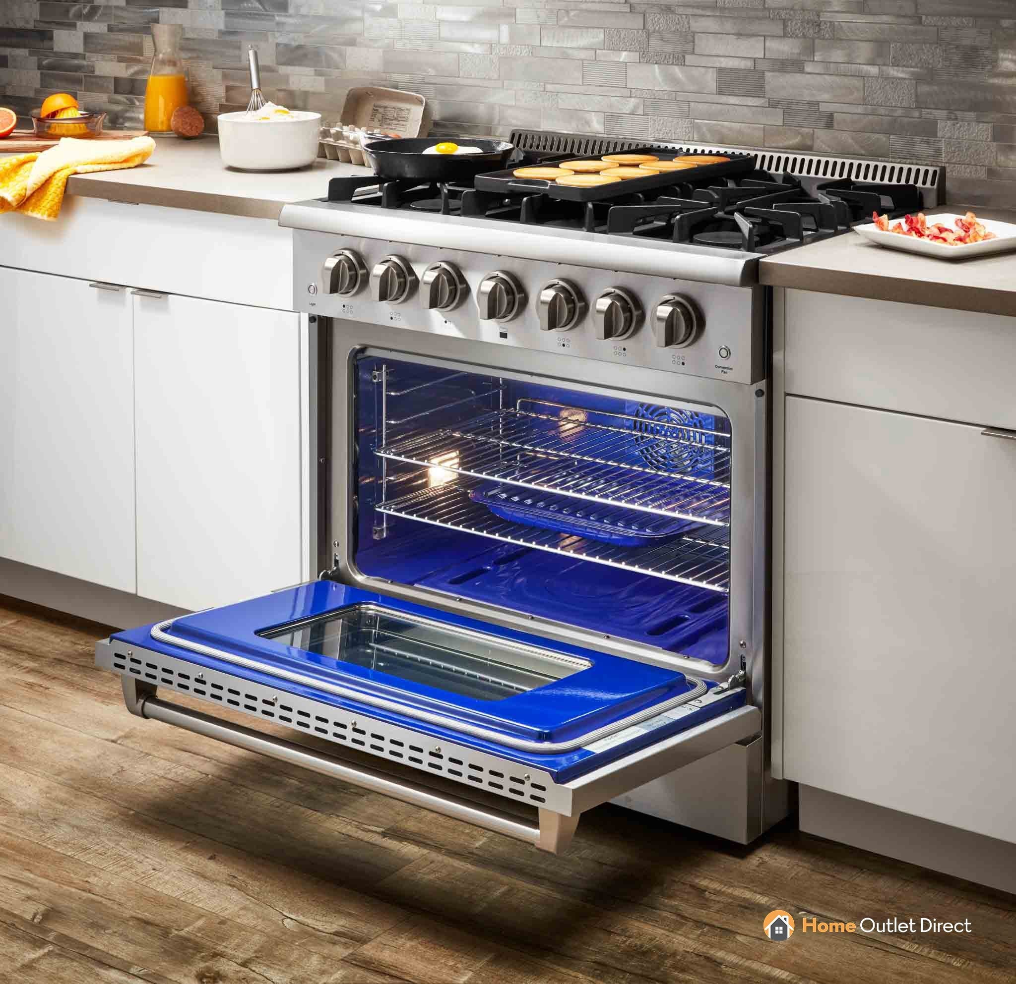Stainless steel gas range with open oven and blue interior, front control knobs